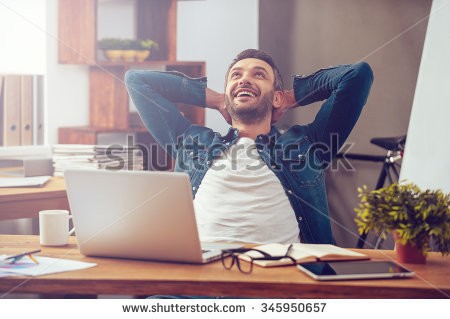 stock-photo-satisfied-with-work-done-happy-young-man-working-on-laptop-while-sitting-at-his-working-p