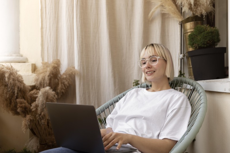 young-blonde-woman-working-from-home-her-chair